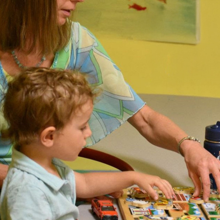 child/girlboy doing a puzzle with teacher in nursery at vineyard church of ithaca