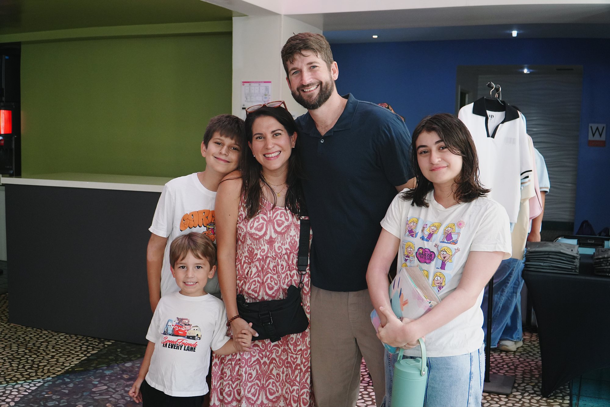 Adults and children smile together in the church lobby.