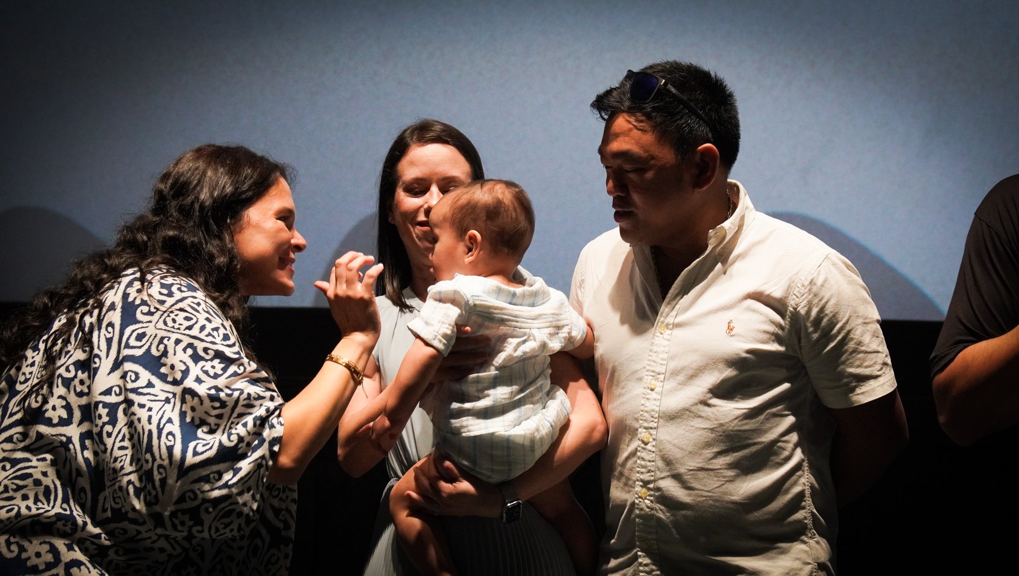 Adults gather with a baby during a church dedication.