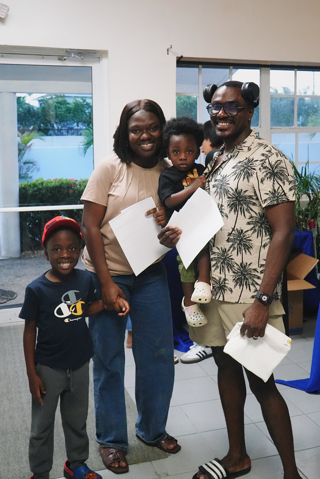 Two adults and two children stand together at a church gathering.