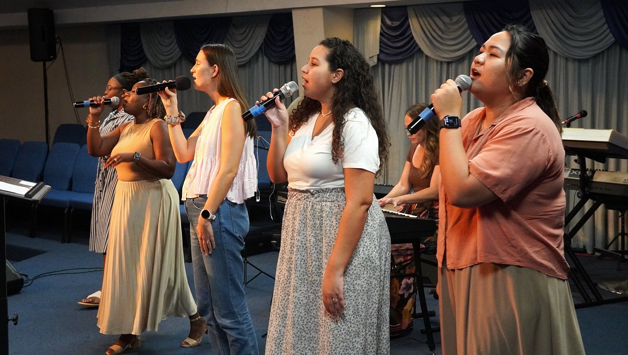 A group sings together with microphones during a church gathering.