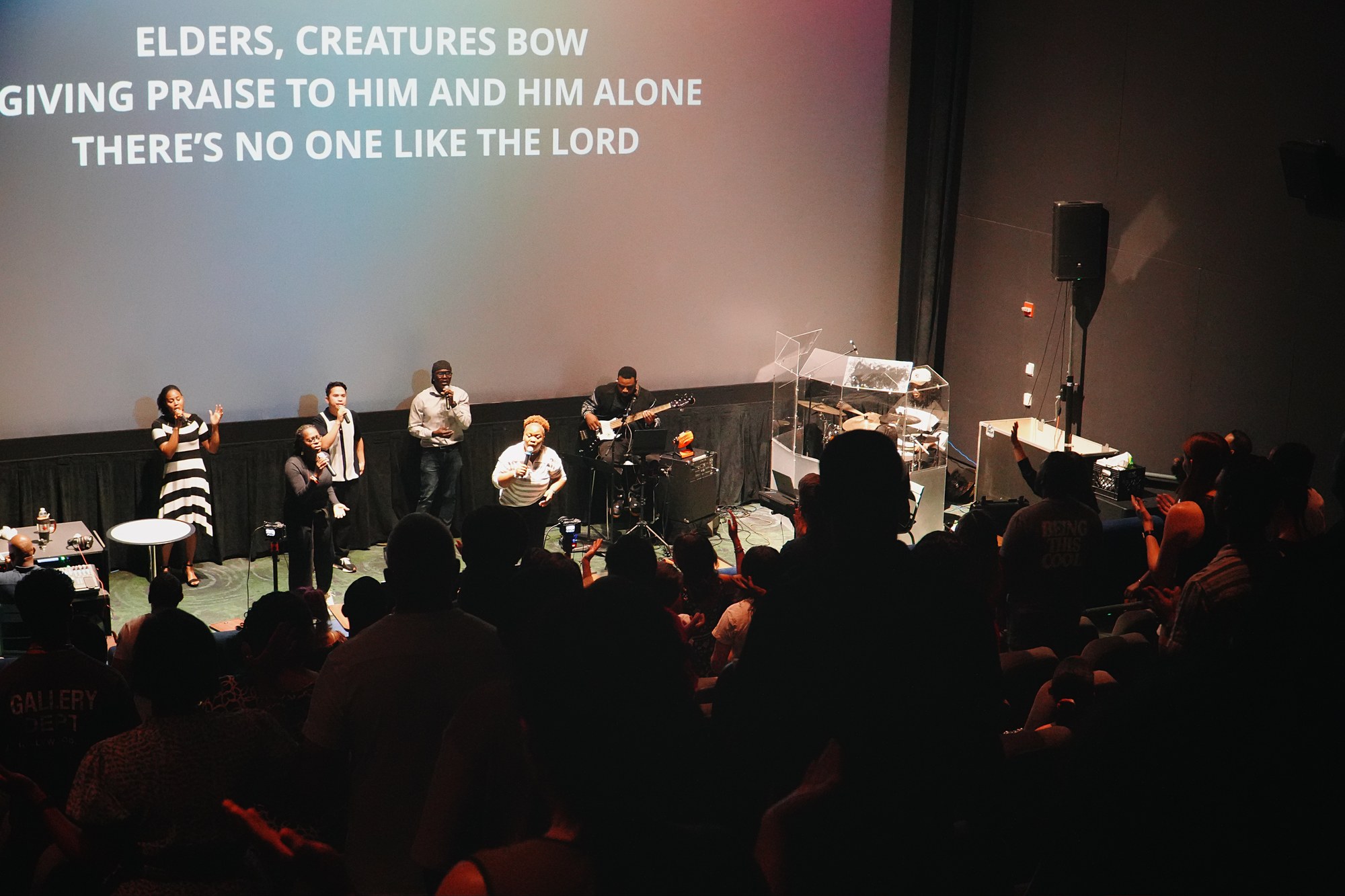 People worship together facing the stage in CIAG's auditorium.
