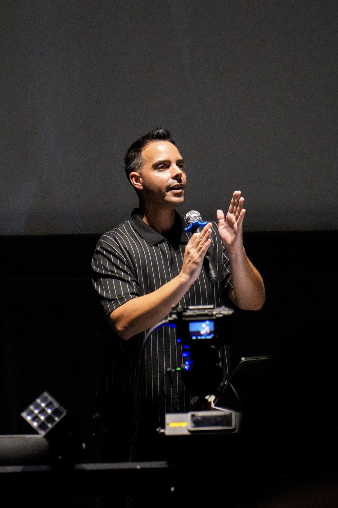 A speaker holds a microphone on stage during a Sunday service.