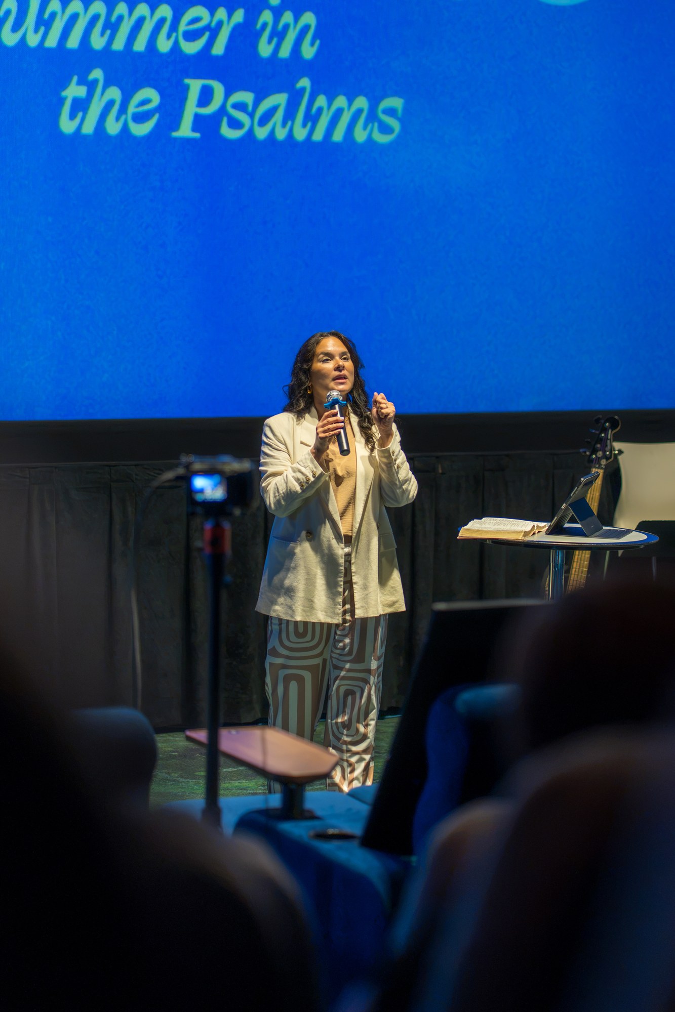A woman speaks from the stage during a Sunday service.