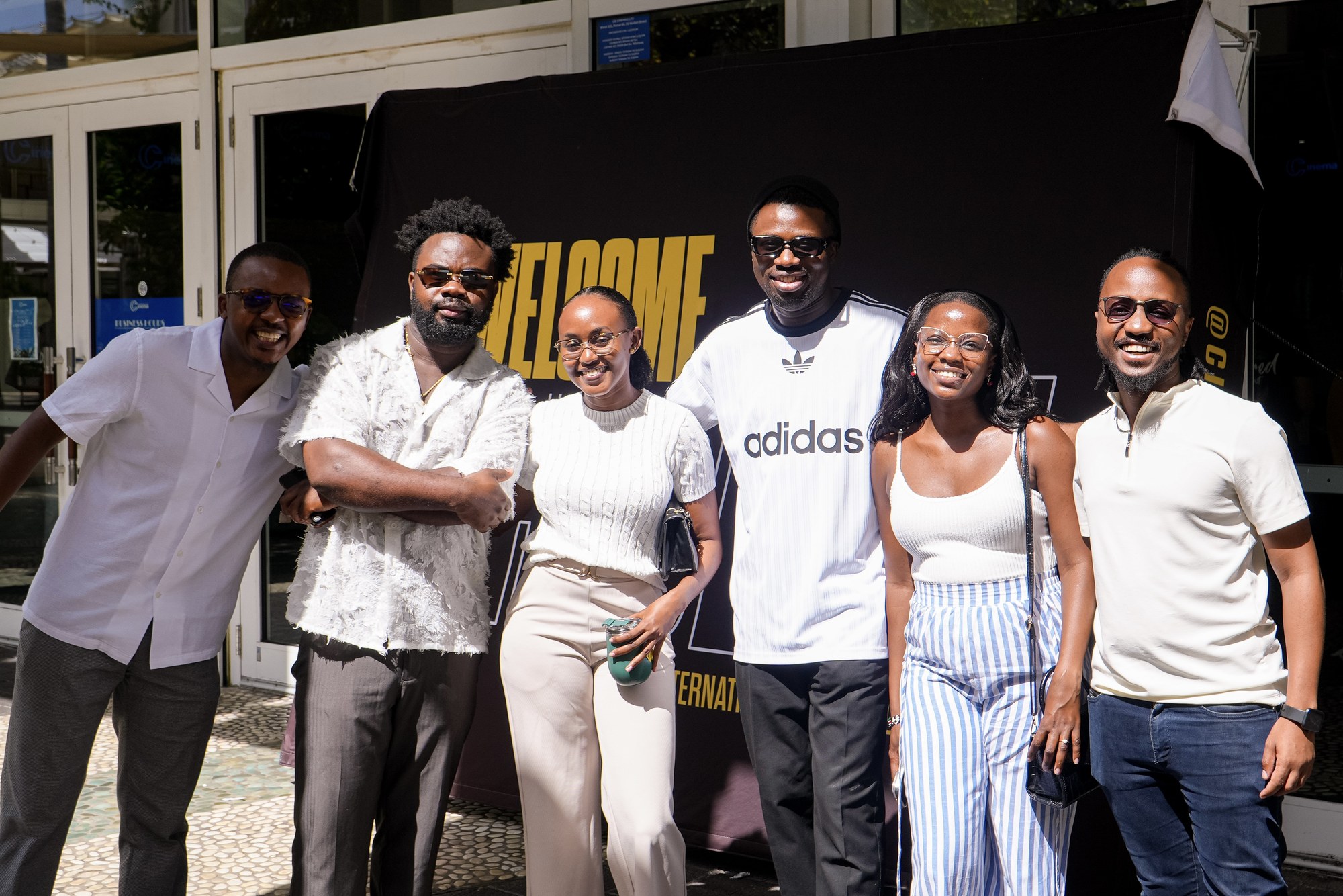 A group smiles together outside beside CIAG's welcome backdrop.
