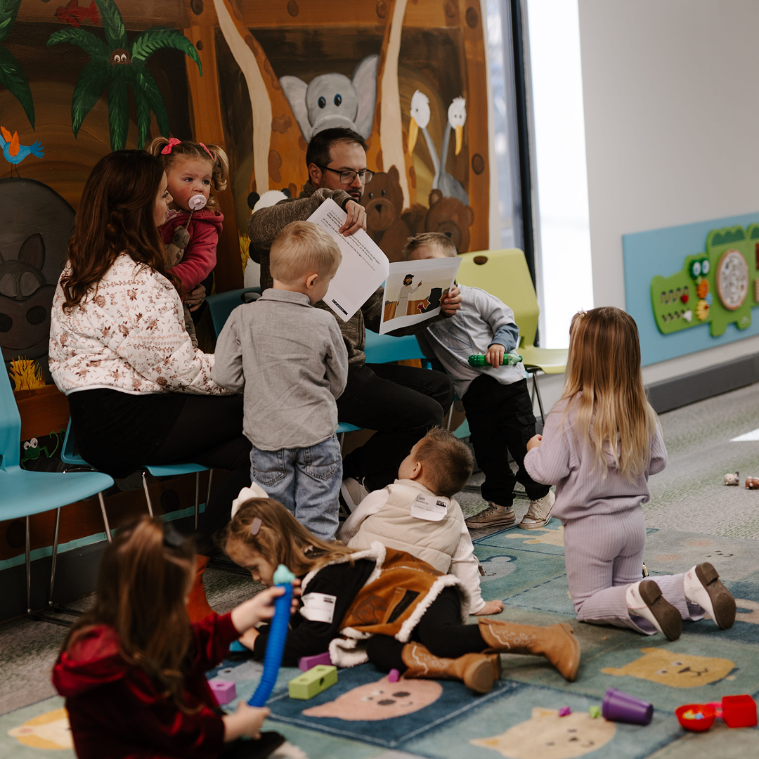 Kids playing at a play room with two adults
