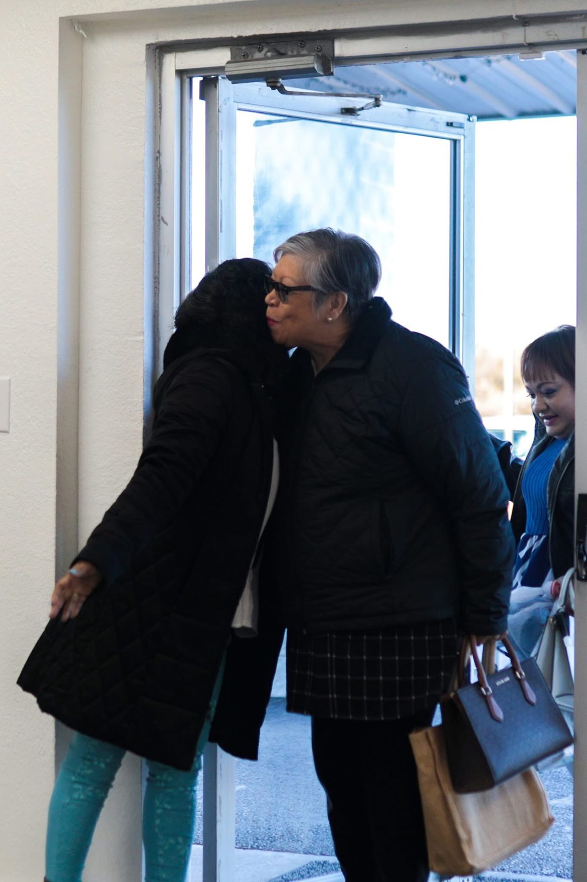 Una hermana recibe con un abrazo a quien llega a la iglesia