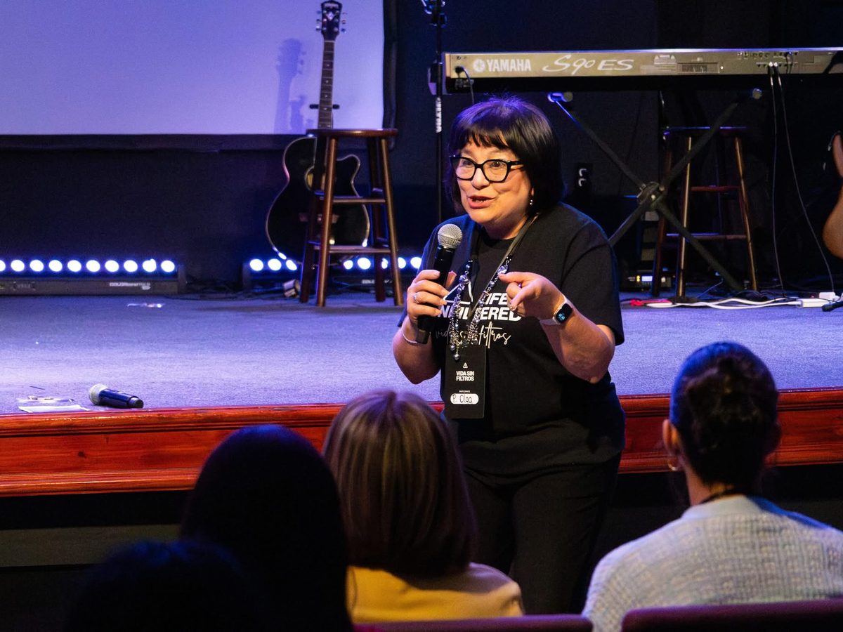 Pastor Olga Roche teaching a class, microphone in hand