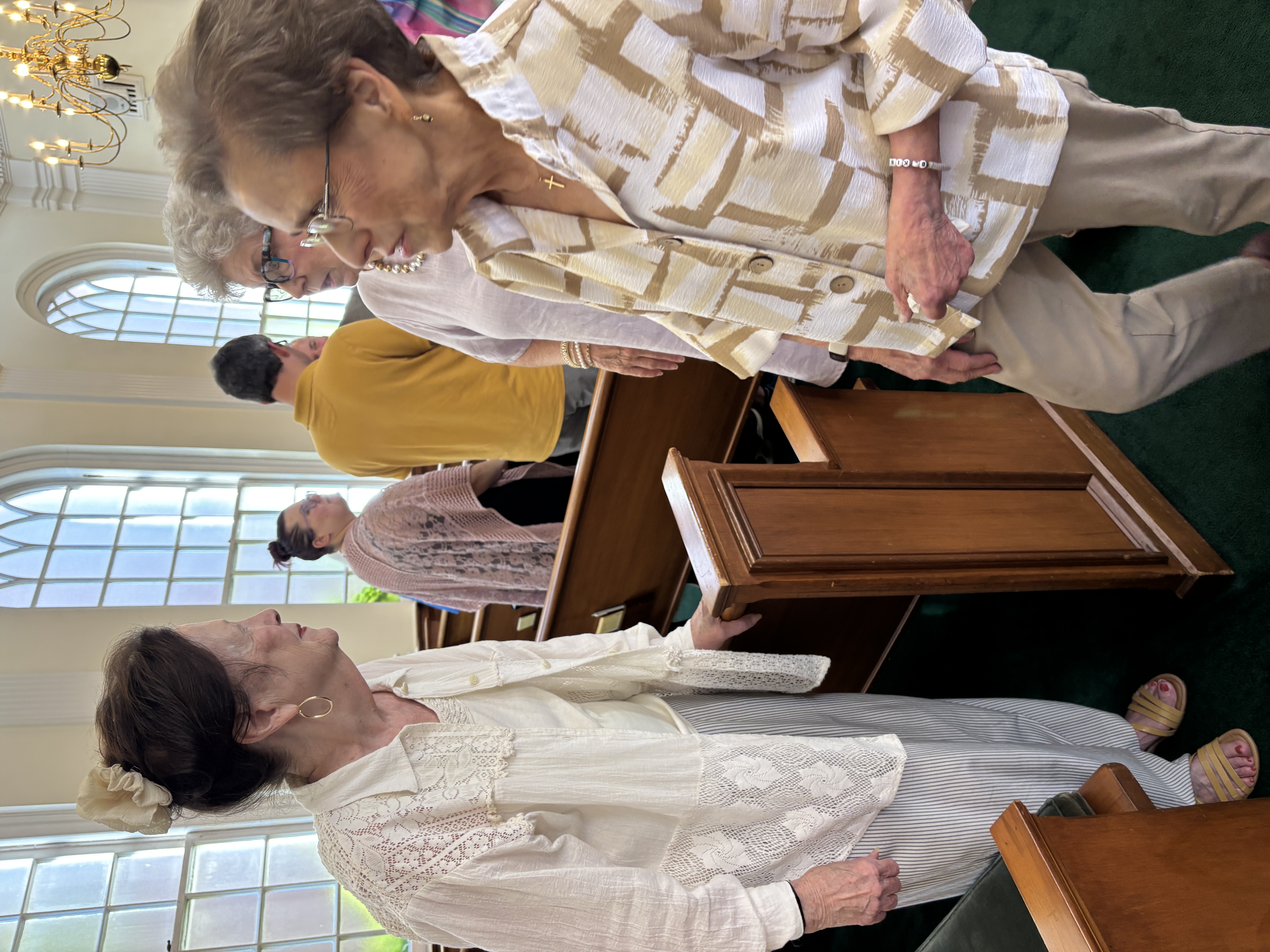 People talking together between the pews after worship in the chapel.