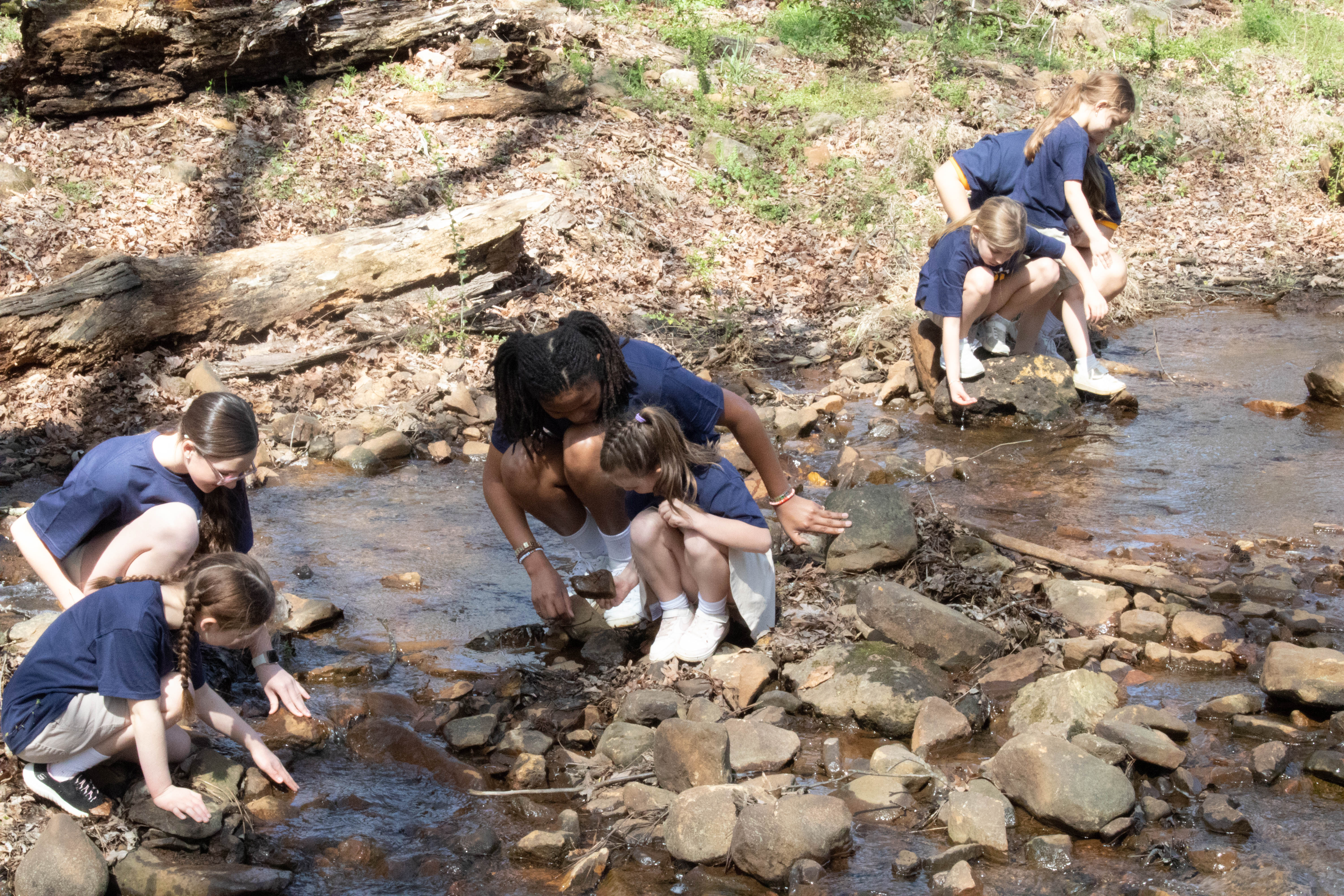 Campers exploring the rocks in the creek at Camp Lee